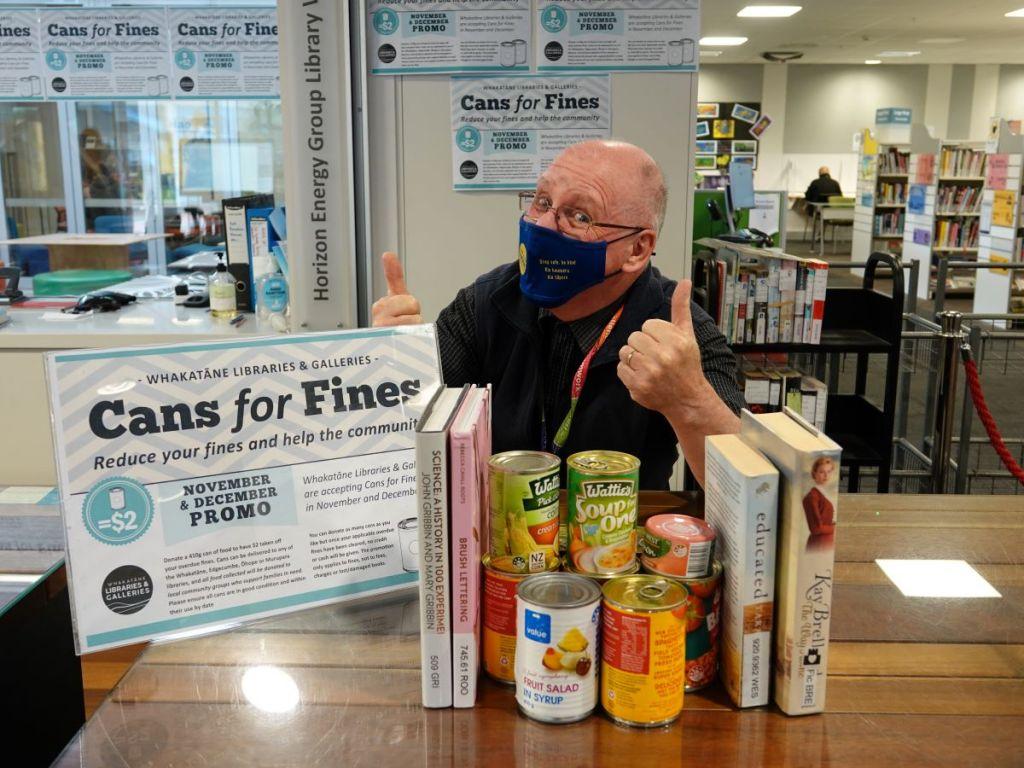 Can it - Whakatāne Libraries and Galleries are encouraging book borrowers to support our community and clear their library fines at the same time John with cans and books