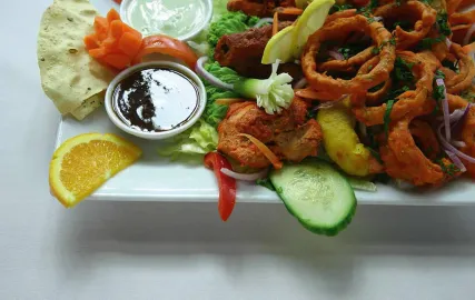 A plate of onion rings and various other assorted nibbles.